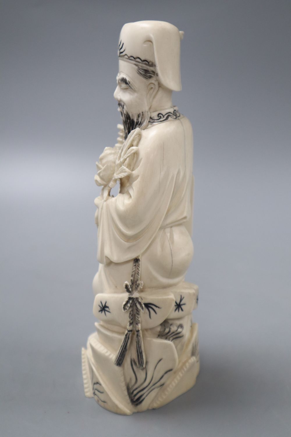 A Chinese ivory man holding flower